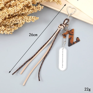 Detail of woven rope keychain with tortoise shell letter Z and motivational pendant