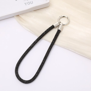 Detailed macro of black rhinestone wrist strap with sparkling luxury metal spring ring buckle