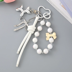Detail of beaded bag charm featuring a silver balloon dog pendant and heart-shaped clasp