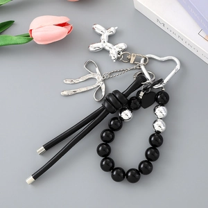 Detail of beaded acrylic keychain with silver balloon dog charm and leather cord decoration