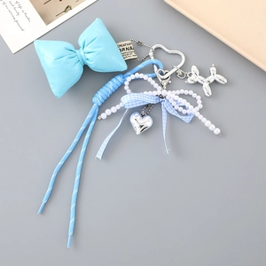Détail d'un bijou de sac nœud bleu avec corde tissée perles et fermoir cœur argenté