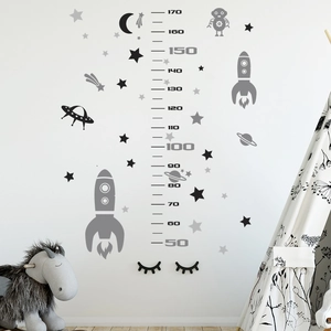 Detailed view of space rocket height chart with astronaut motifs on white wall