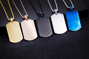 Close-up of titanium steel dog tag necklaces in five metallic colors on black steps
