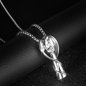 Vue latérale macro du pendentif ange en argent avec une chaîne en acier inoxydable poli