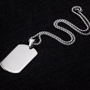 Macro view of polished silver dog tag pendant with rounded edges and round box chain