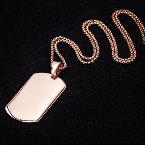 Macro shot of rose gold rectangular dog tag pendant on box chain with mirror finish