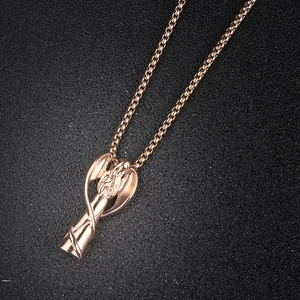 Vue détaillée du pendentif ange cinéraire en or rose avec une chaîne maille sur fond noir