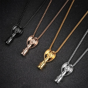 Détail macro de pendentifs d'ange funéraires en noir, doré, or rose et argent poli