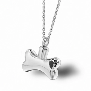 Polished stainless steel dog bone cremation urn necklace with black paw print design