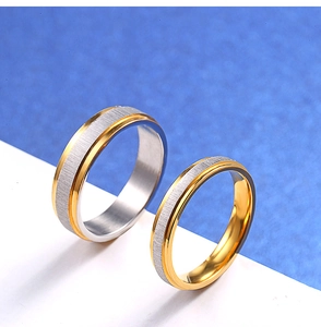 Detail of brushed silver and polished gold two-tone stainless steel couple rings