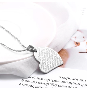 Vue détaillée du pendentif cœur en acier inoxydable gravé avec le texte du Notre Père