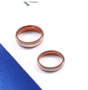 Macro detail of brushed silver and rose gold polished stainless steel couple rings