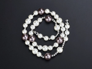 Close-up of hip-hop pearl necklace with white and purple beads and metal spacers