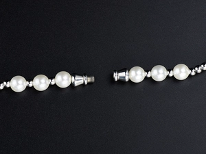 Macro shot of the vintage pearl necklace featuring a secure silver screw clasp closure