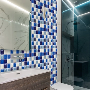 Detailed view of blue and white mosaic tile stickers on a modern bathroom wall