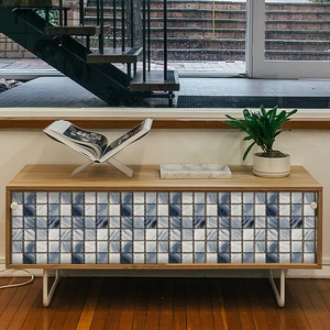 Autocollants mosaïque bleus et blancs posés sur un buffet en bois clair dans un salon