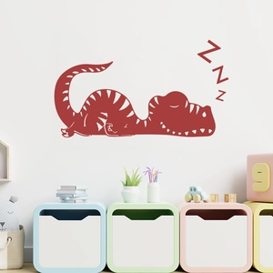 Détail d'un sticker mural dinosaure rouge endormi avec symboles ZZZ pour chambre d'enfant