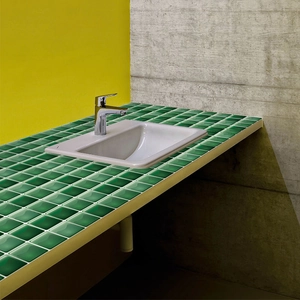 Detail of green 3D mosaic peel and stick tile installed on bathroom countertop