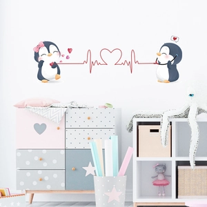 Detail of cute cartoon penguin wall decals in a cozy kids room with heart accents