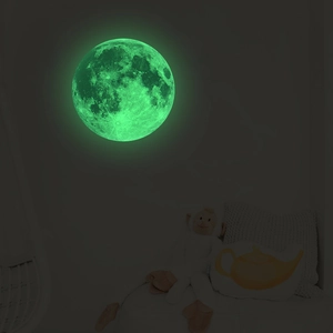 Luminous moon wall sticker showing glowing green lunar texture in a dark bedroom setting