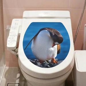 Adhesive toilet lid decal featuring a realistic penguin standing on rocks by the deep blue sea