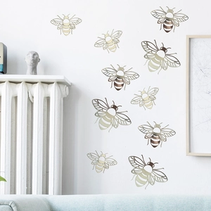 3D hollow metallic bee wall stickers in gold and bronze finish on a white wall