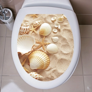 Macro detail of waterproof 3D toilet lid sticker featuring realistic beach sand and shells