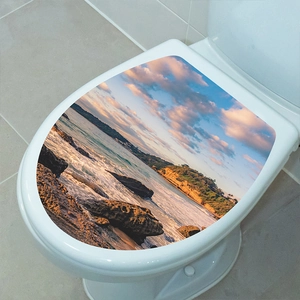 Detailed close-up of a self-adhesive toilet lid sticker with a scenic coastal sunset print