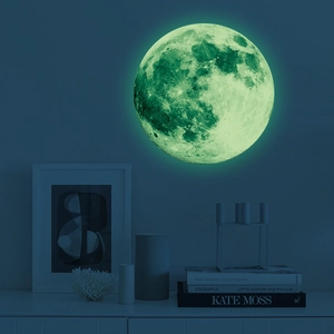 Luminous 30cm moon wall sticker glowing green in a dark bedroom with crater textures