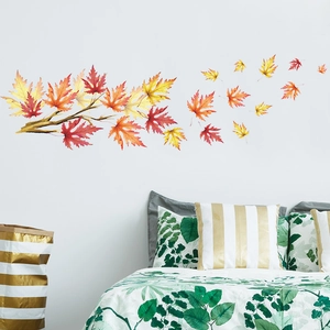 Détail de stickers muraux feuilles d'érable sur un mur blanc au-dessus d'un lit