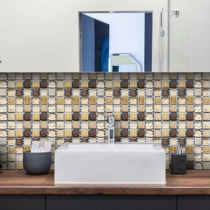 Detail of self-adhesive mosaic wall tiles in gold and brown for bathroom backsplash