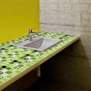 Detail of green mosaic self-adhesive tile stickers applied on a bathroom sink surface
