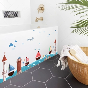 Self-adhesive nautical wall stickers with lighthouses and sailboats on a white bathtub