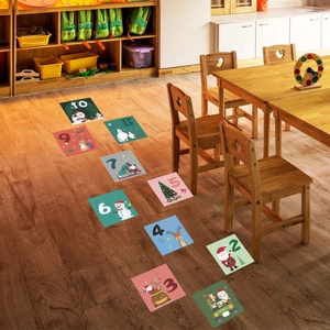 Close-up of Christmas hopscotch floor decals with Santa and snowman on wood background