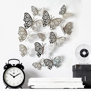 Silver 3D laser-cut hollow butterfly wall decals arranged on a textured white wall