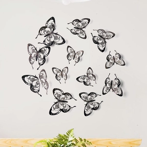 Detailed view of 12pcs 3D black and white hollow butterfly wall stickers on white wall