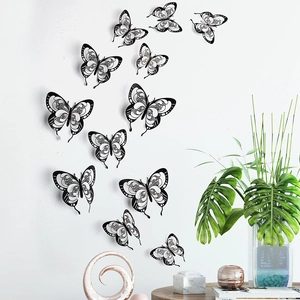 Set of 12 black 3D hollow butterfly wall stickers displayed on a white living room wall