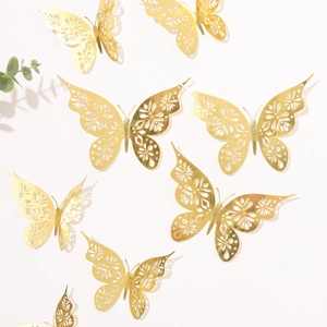 Detailed view of hollow gold butterfly wall stickers with intricate floral cutout patterns