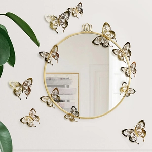 Detailed 3D hollow gold paper butterfly wall stickers showing laser-cut patterns on a white wall