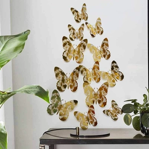 Close-up of golden hollow butterfly wall stickers with intricate floral cutout patterns