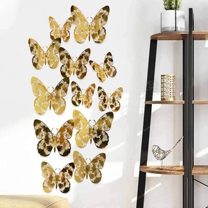 Golden 3D cutout butterfly wall stickers with intricate laser patterns on a white wall