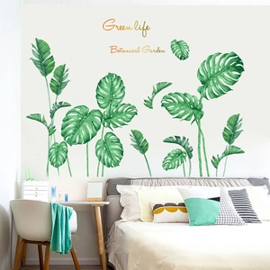 Detail showing tropical monstera leaf wall stickers in a cozy bedroom setting