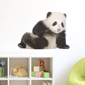 Close-up of a cute panda wall sticker in a kids room with modern white shelf and toys
