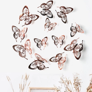 Artistic circular arrangement of 12 rose gold 3D hollow butterfly wall decals on white wall