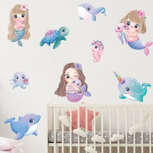 Détail de stickers muraux sirène et baleine aux tons pastels dans une chambre d'enfant