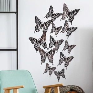 Detailed laser-cut hollow butterfly wall stickers displayed on a white wall in a modern room