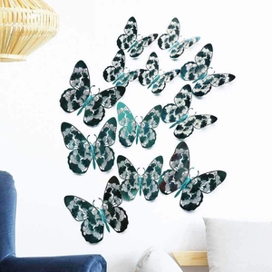 Detailed 3D hollow butterfly wall stickers in teal with white floral patterns on a white wall