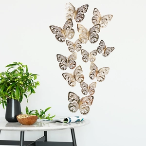 Nahaufnahme goldener 3D-Hohl-Schmetterlinge mit Blumenmustern an einer Wand