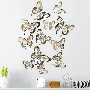 Detailed view of 3D hollow gold butterfly wall decals in various patterns on a white wall