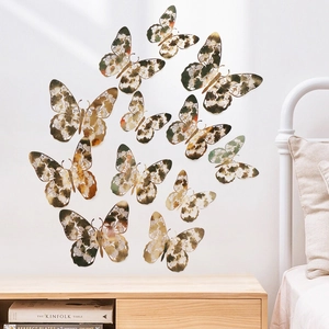 Macro shot of 12-piece vintage bronze hollow 3D butterfly wall stickers on white wall